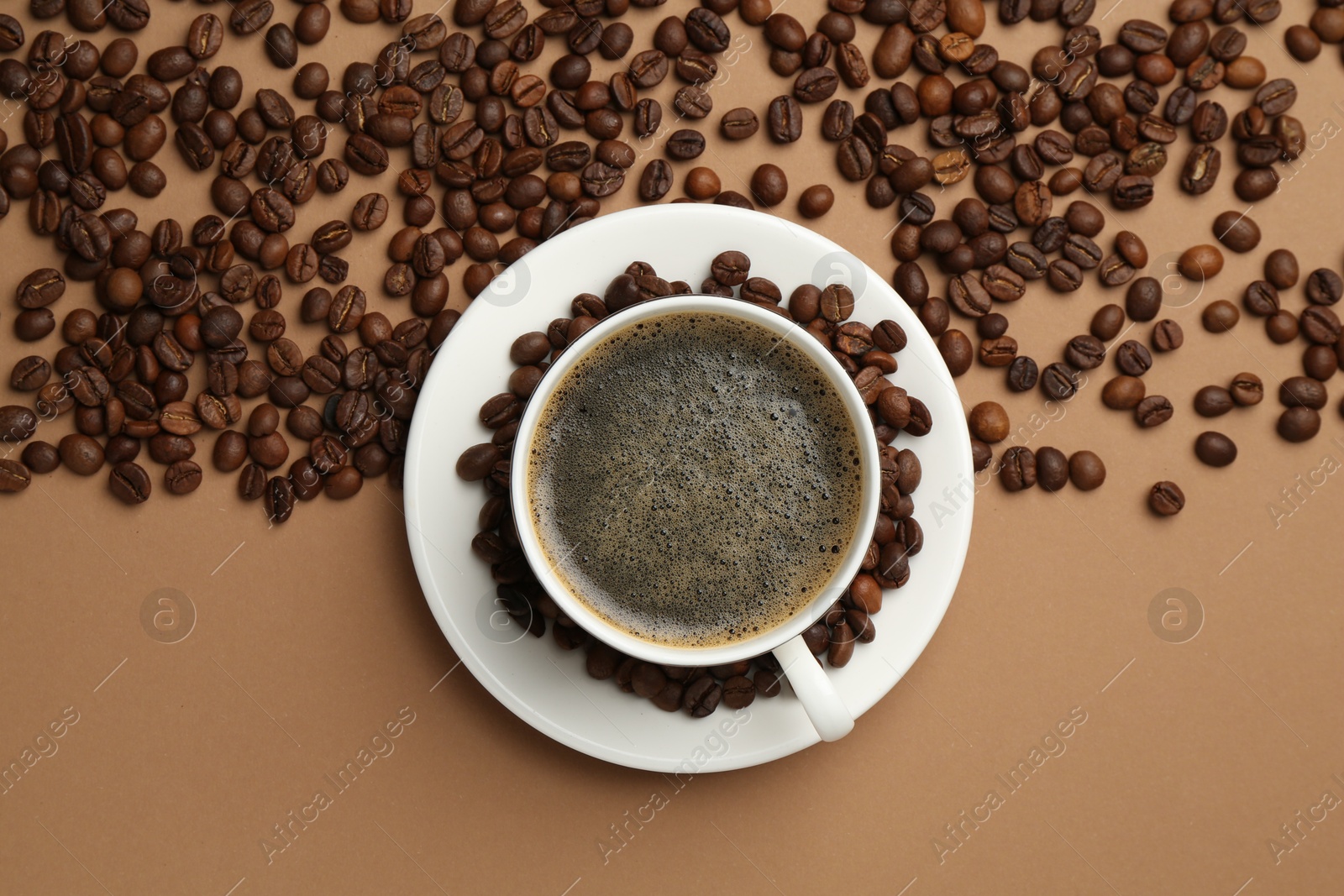 Aromatic coffee in cup and beans on beige background, flat lay Photo of Aromatic coffee in cup and beans on beige background, flat lay