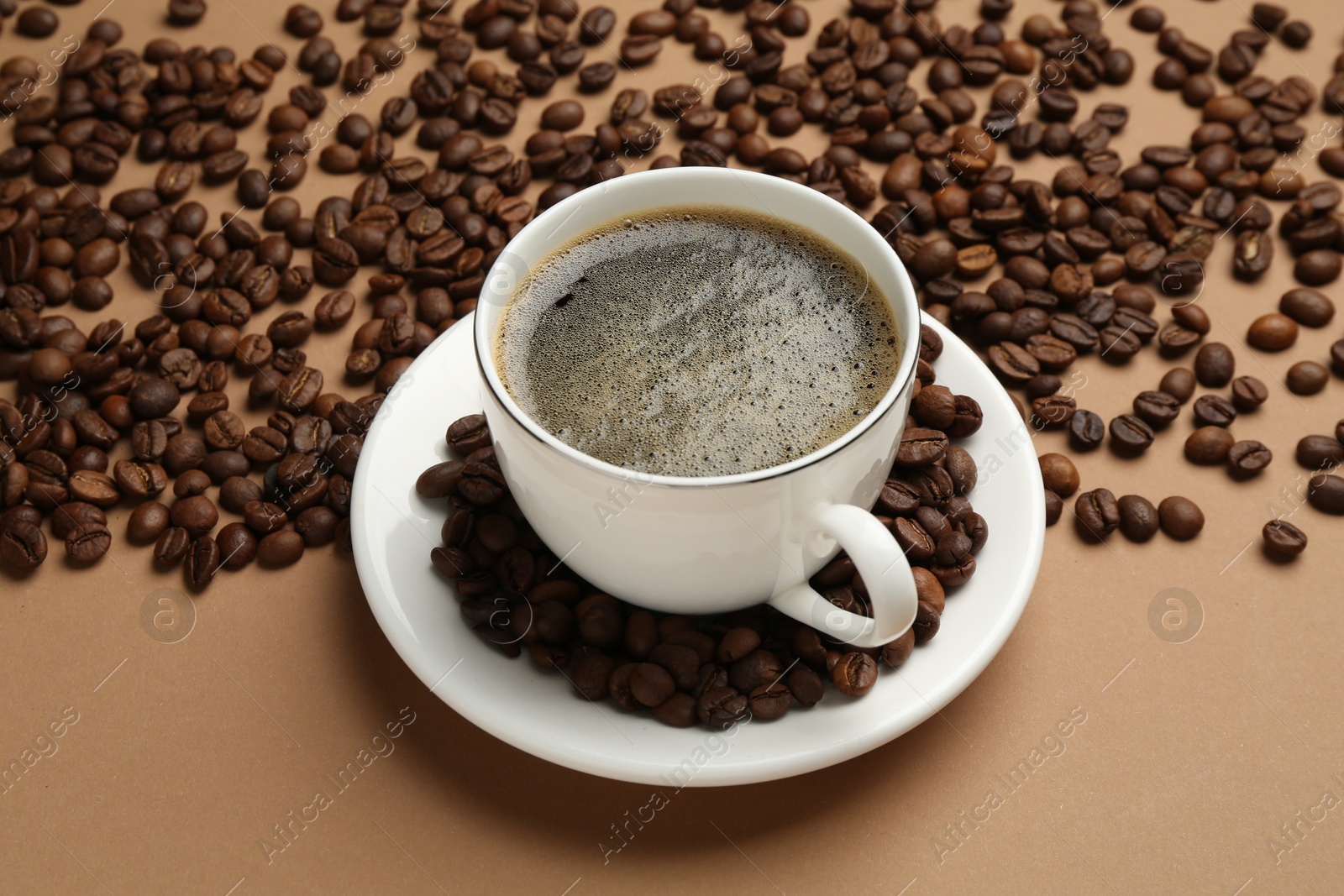 Aromatic coffee in cup and beans on beige background, above view Photo of Aromatic coffee in cup and beans on beige background, above view