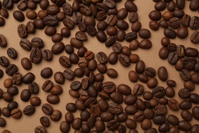 Photo of Aromatic coffee beans on beige background, flat lay