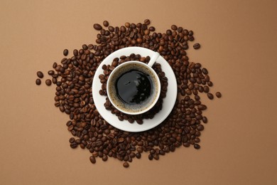 Photo of Aromatic coffee in cup and beans on beige background, flat lay
