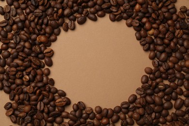 Photo of Frame of aromatic coffee beans on beige background, flat lay. Space for text