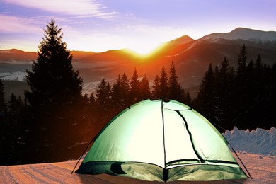 Image of Camping tent on snow in mountains at sunrise