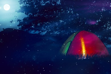 Image of Camping tent lit from inside in wilderness at night