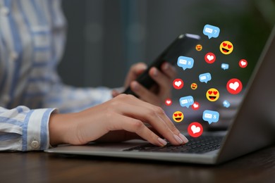 Image of Woman using laptop and mobile phone at table, closeup. Social media notifications (messages, likes, emojis) flying out of computer