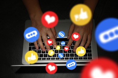 Image of Man using laptop at night, top view. Social media notifications (messages, likes, emojis) flying out of computer