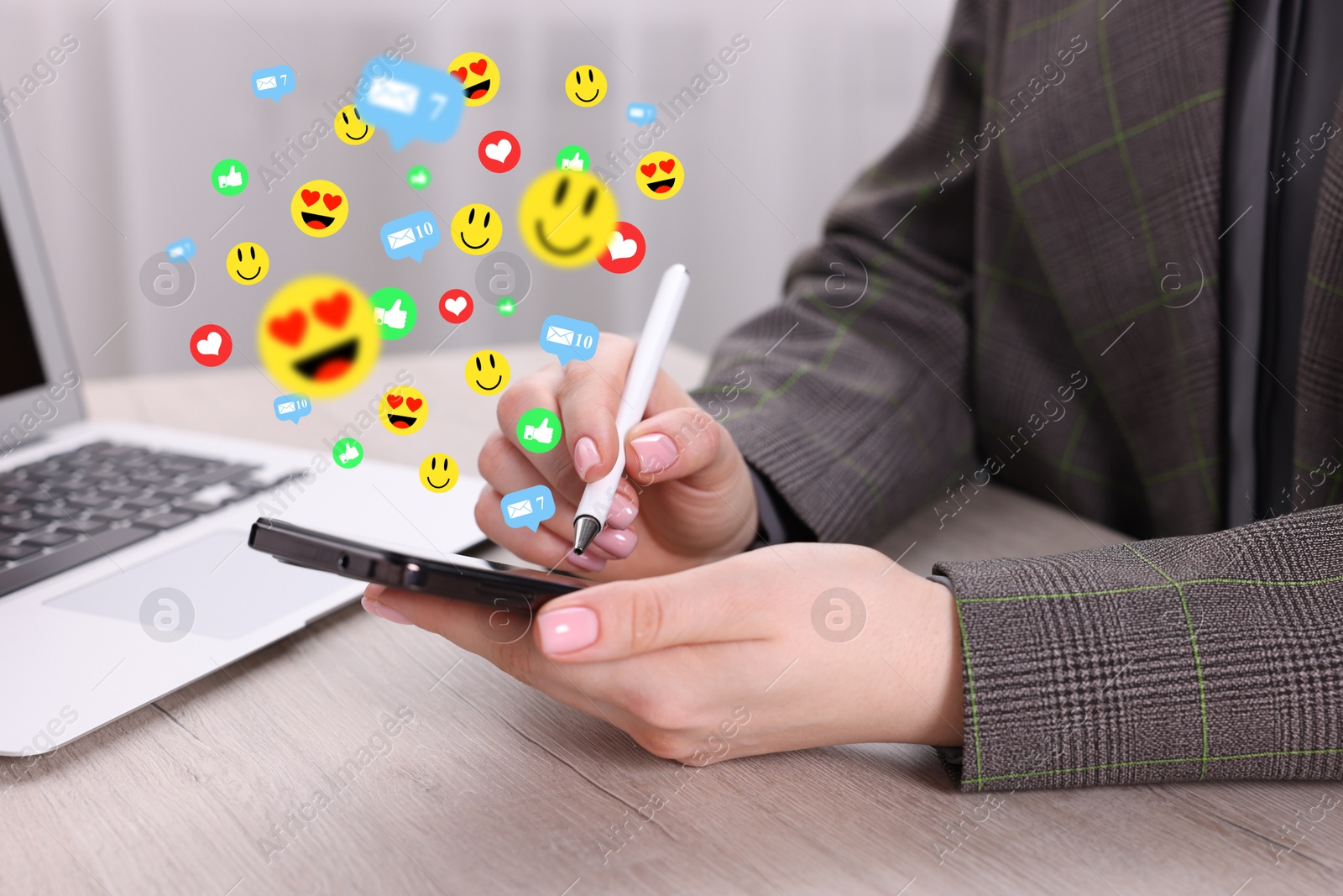 Woman using smartphone at table, closeup. Social media notifications (likes, messages and emojis) flying out of device Image of Woman using smartphone at table, closeup. Social media notifications (likes, messages and emojis) flying out of device