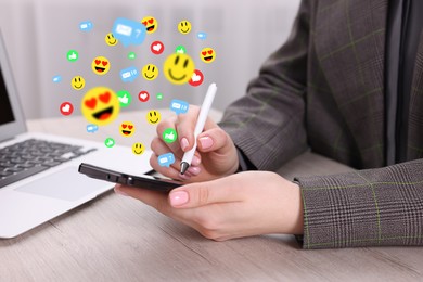 Image of Woman using smartphone at table, closeup. Social media notifications (likes, messages and emojis) flying out of device