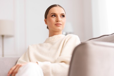 Photo of Portrait of beautiful young woman on sofa at home