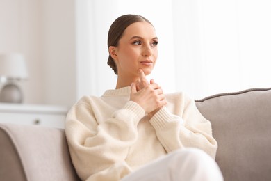Photo of Portrait of beautiful young woman on sofa at home