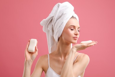 Photo of Beautiful woman with soap bars on pink background