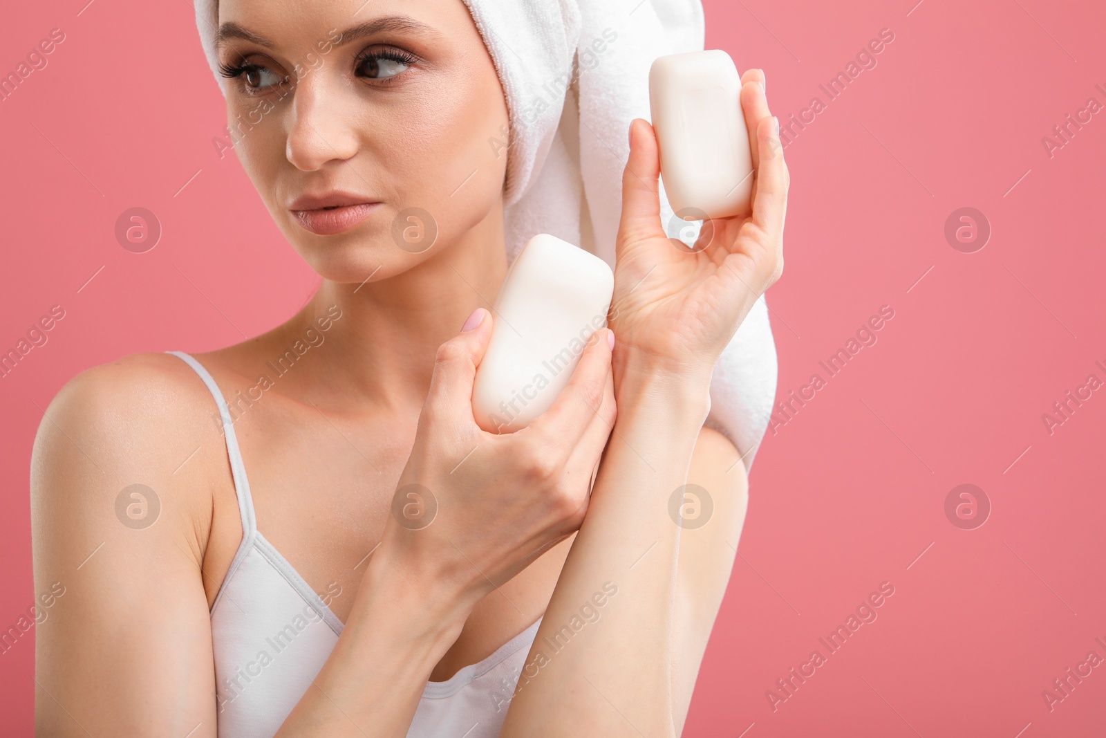 Beautiful woman with soap bars on pink background Photo of Beautiful woman with soap bars on pink background