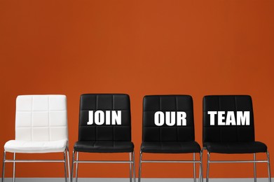 Image of Black chairs with words Join Our Team and empty white one near orange wall. Recruitment, human resource concept