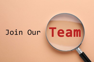 Image of Join Our Team. Magnifying glass on beige background, top view. Recruitment, human resource concept