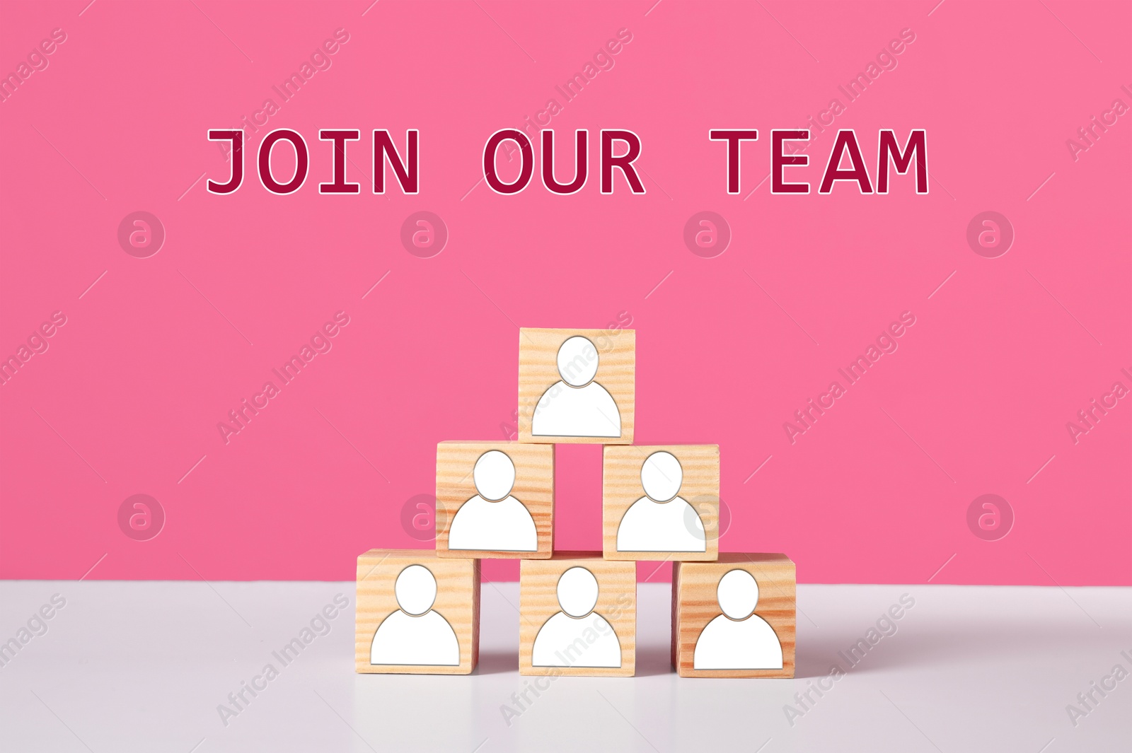 Join Our Team. Pyramid of wooden cubes with human icons on white table against pink background. Recruitment, human resource concept Image of Join Our Team. Pyramid of wooden cubes with human icons on white table against pink background. Recruitment, human resource concept