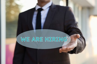 Image of We Are Hiring. Man offering helping hand outdoors, closeup. Recruitment, human resource concept