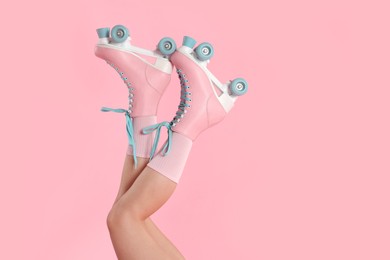 Photo of Woman in roller skates on pink background, closeup. Space for text