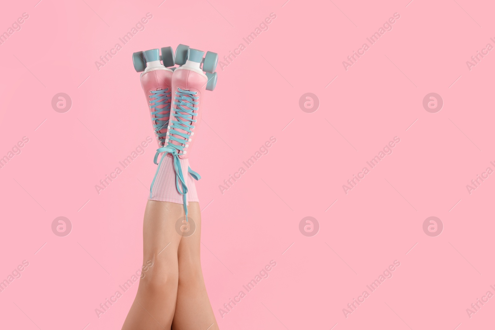 Photo of Woman in roller skates on pink background, closeup. Space for text