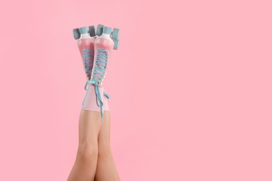 Photo of Woman in roller skates on pink background, closeup. Space for text