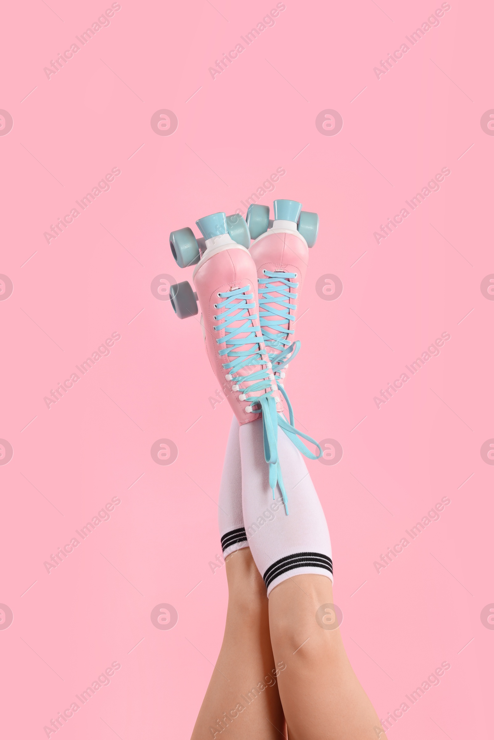 Woman in roller skates on pink background, closeup Photo of Woman in roller skates on pink background, closeup