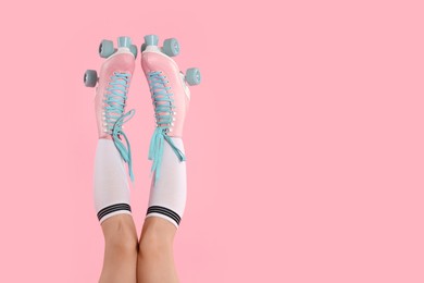 Photo of Woman in roller skates on pink background, closeup. Space for text