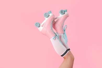 Photo of Woman in roller skates on pink background, closeup