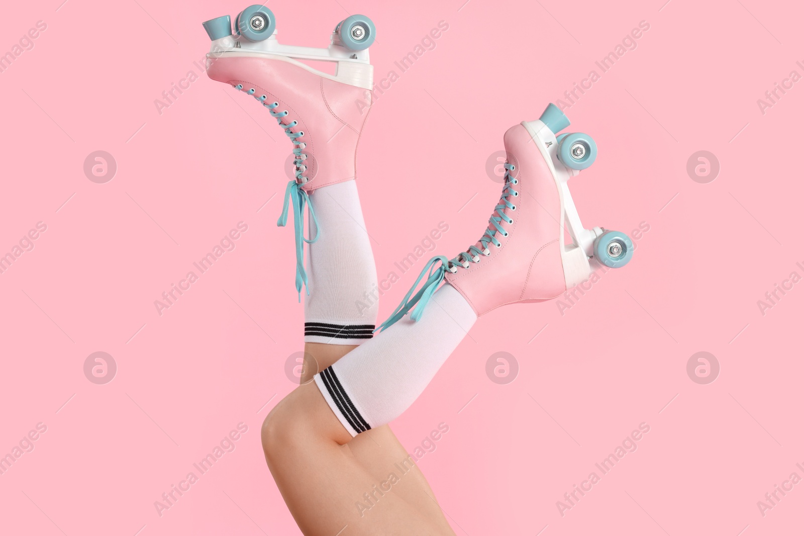 Woman in roller skates on pink background, closeup Photo of Woman in roller skates on pink background, closeup