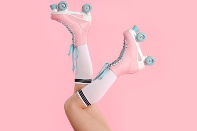 Photo of Woman in roller skates on pink background, closeup