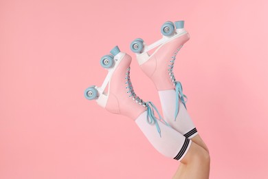 Photo of Woman in roller skates on pink background, closeup. Space for text