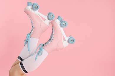 Photo of Woman in roller skates on pink background, closeup. Space for text