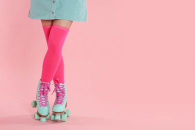 Photo of Woman in roller skates on pink background, closeup. Space for text
