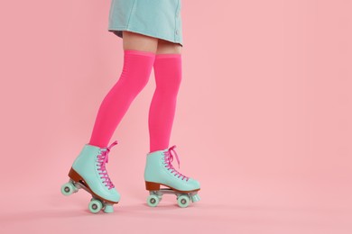 Photo of Woman in roller skates on pink background, closeup. Space for text