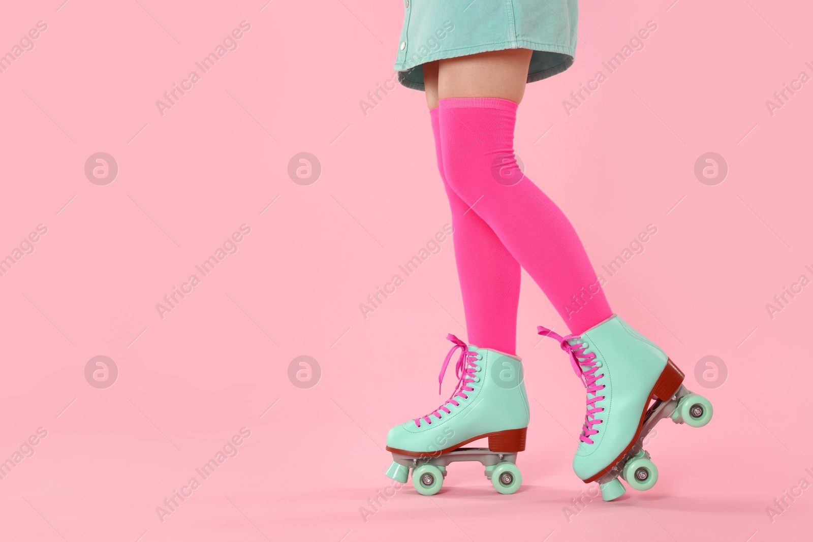 Woman in roller skates on pink background, closeup. Space for text Photo of Woman in roller skates on pink background, closeup. Space for text