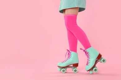 Photo of Woman in roller skates on pink background, closeup. Space for text
