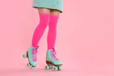Photo of Woman in roller skates on pink background, closeup. Space for text