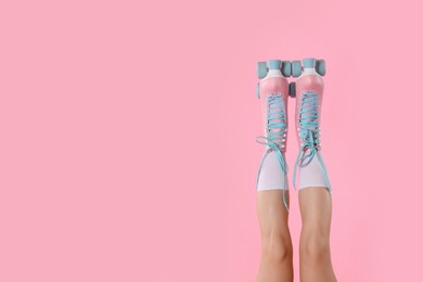 Photo of Woman in roller skates on pink background, closeup. Space for text