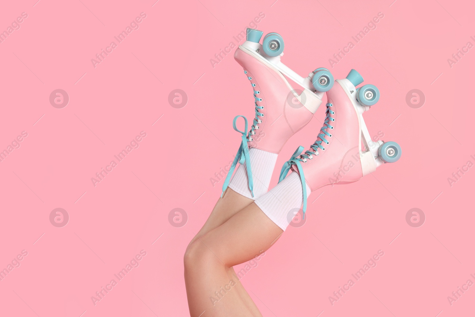 Woman in roller skates on pink background, closeup Photo of Woman in roller skates on pink background, closeup