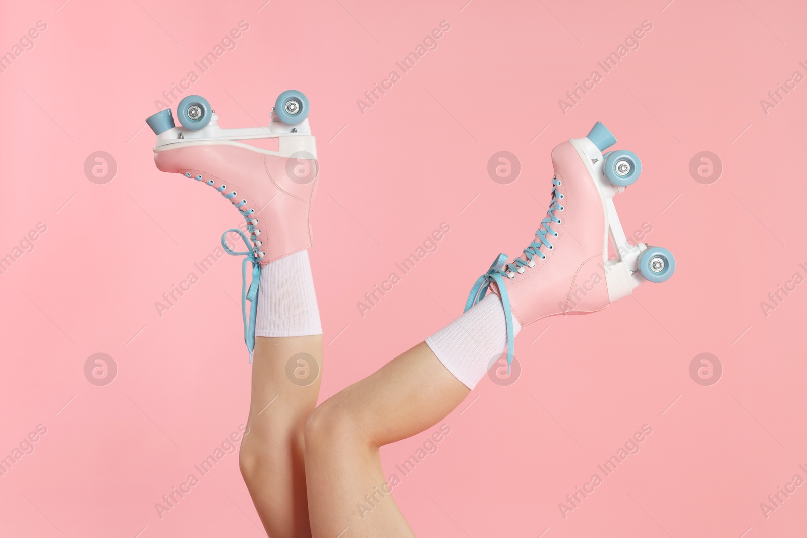 Woman in roller skates on pink background, closeup Photo of Woman in roller skates on pink background, closeup