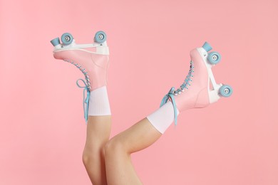 Photo of Woman in roller skates on pink background, closeup