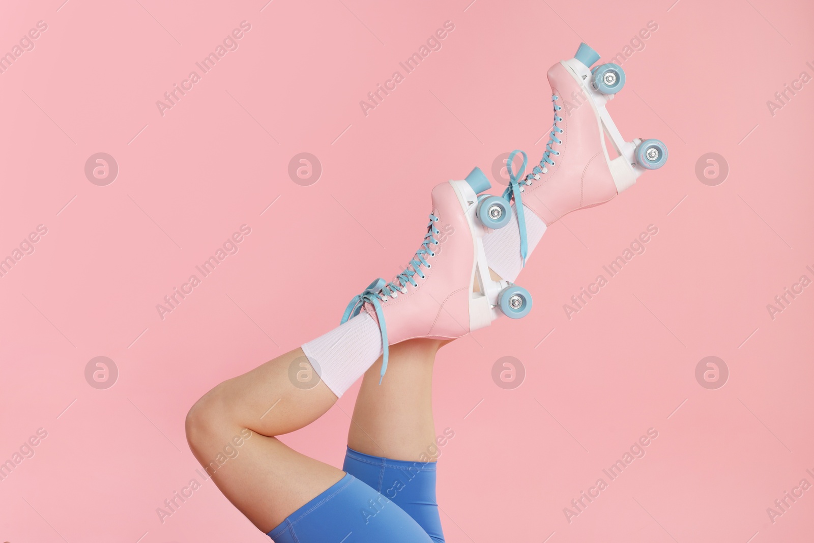Woman in roller skates on pink background, closeup Photo of Woman in roller skates on pink background, closeup