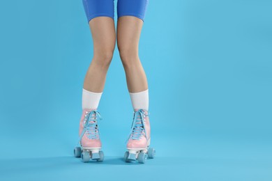 Photo of Woman in roller skates on light blue background, closeup. Space for text