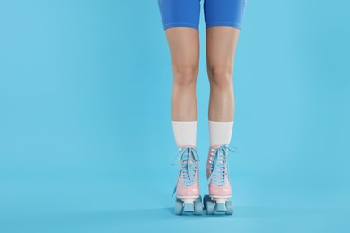 Photo of Woman in roller skates on light blue background, closeup. Space for text