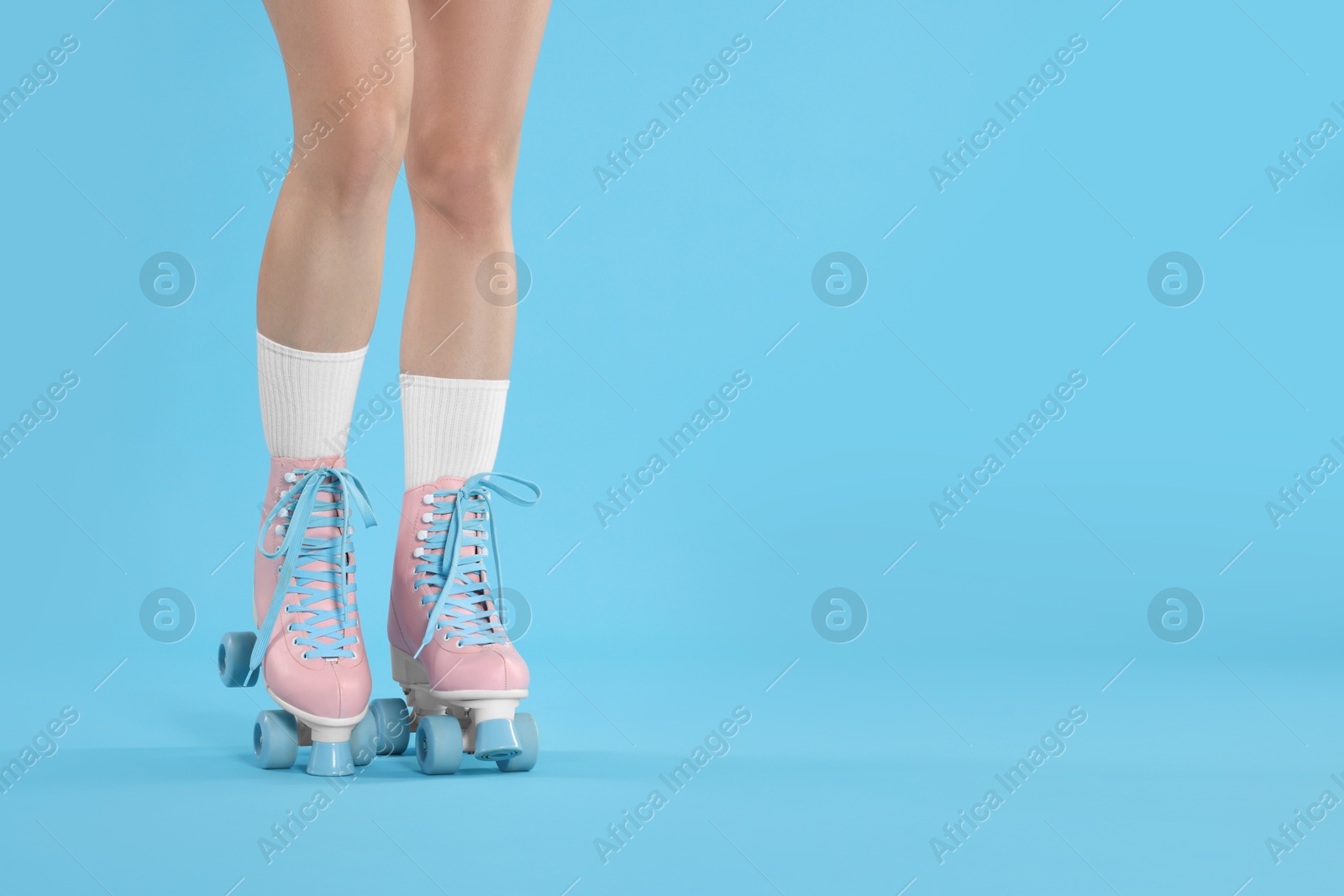 Woman in roller skates on light blue background, closeup. Space for text Photo of Woman in roller skates on light blue background, closeup. Space for text