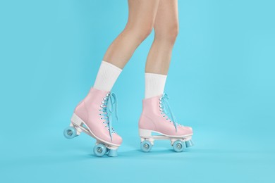 Photo of Woman in roller skates on light blue background, closeup