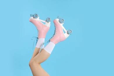 Photo of Woman in roller skates on light blue background, closeup. Space for text