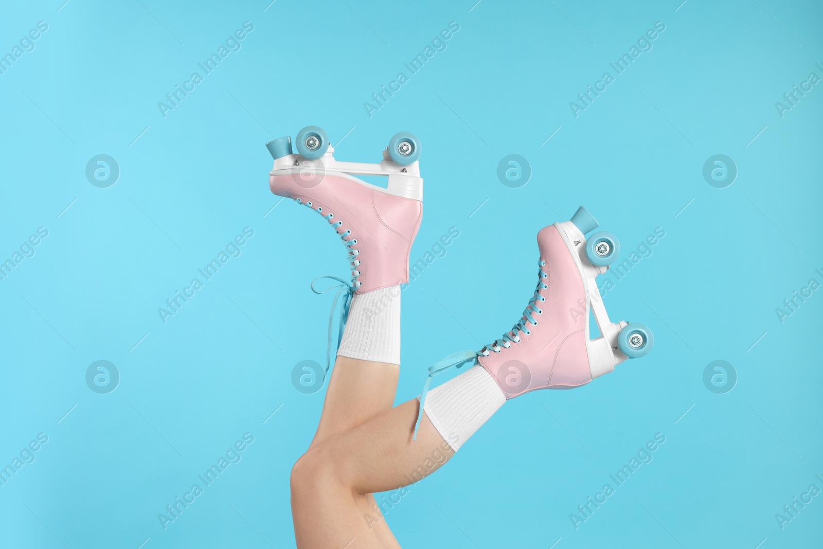 Woman in roller skates on light blue background, closeup Photo of Woman in roller skates on light blue background, closeup