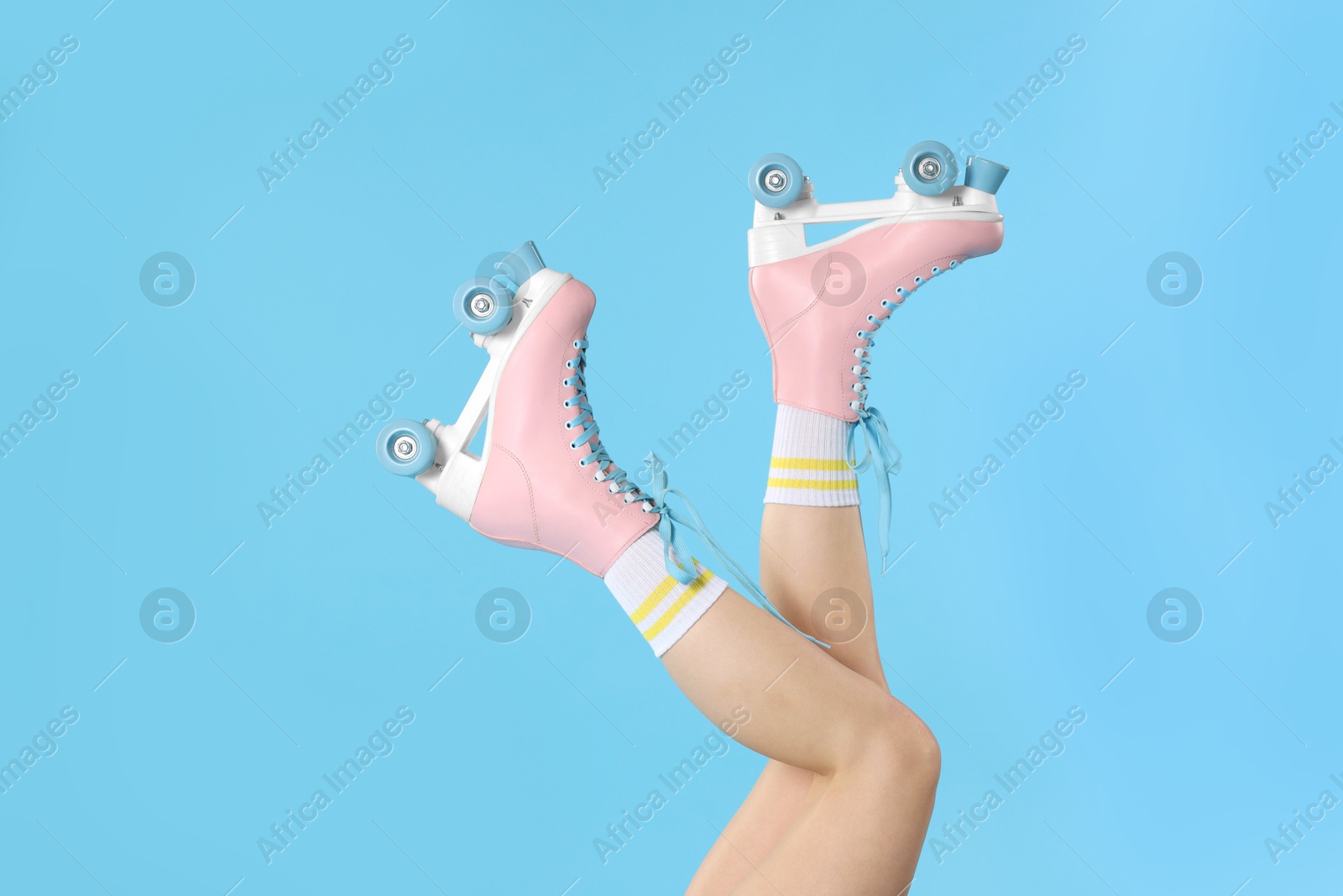 Woman in roller skates on light blue background, closeup Photo of Woman in roller skates on light blue background, closeup