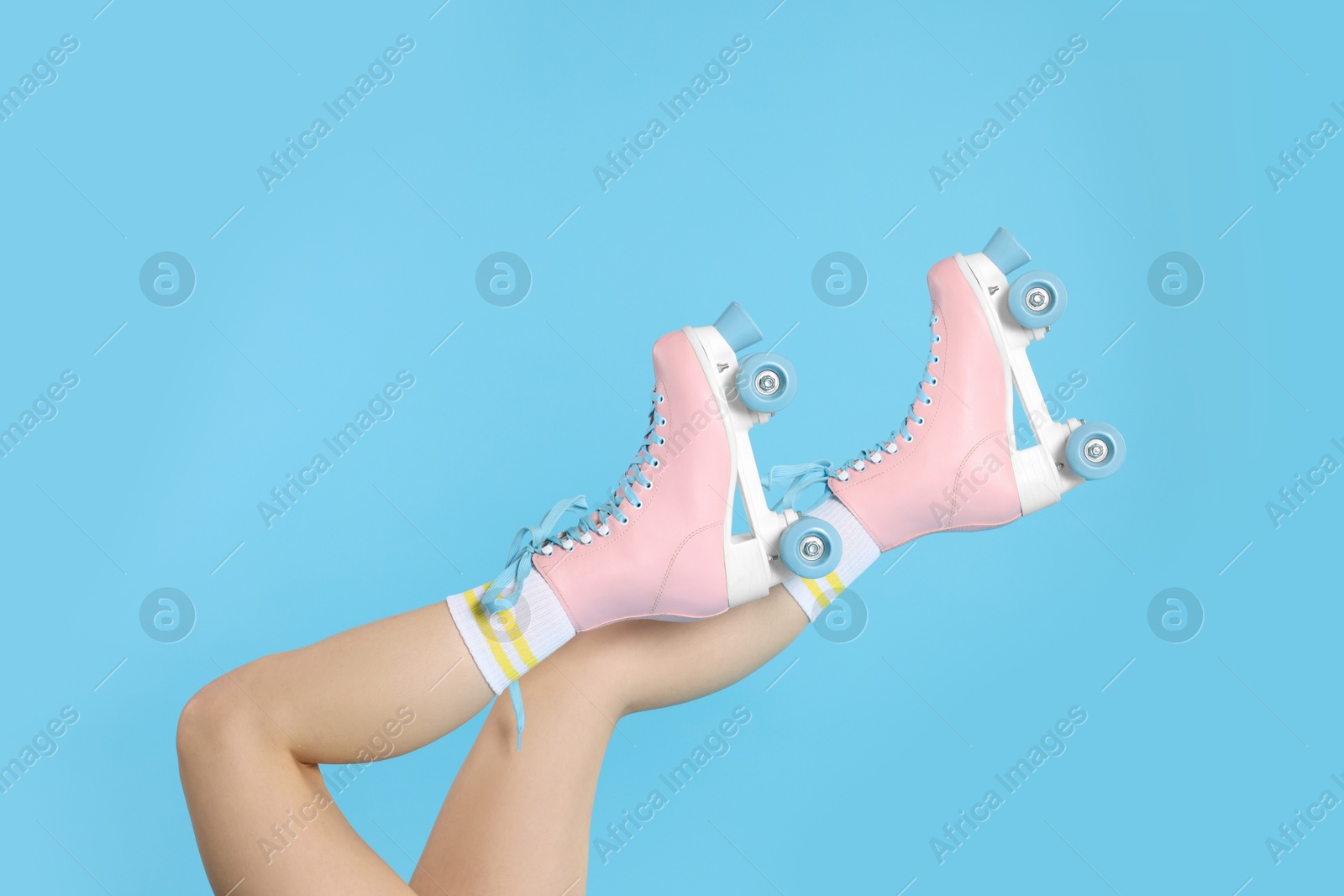 Woman in roller skates on light blue background, closeup Photo of Woman in roller skates on light blue background, closeup