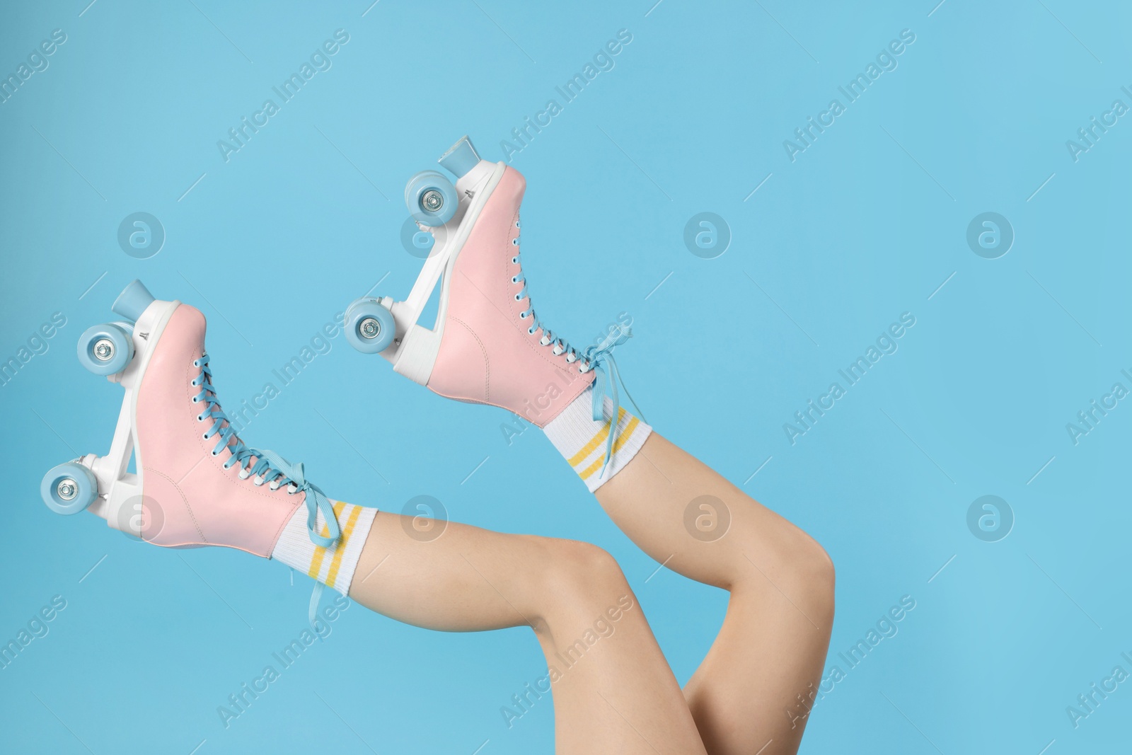 Woman in roller skates on light blue background, closeup Photo of Woman in roller skates on light blue background, closeup