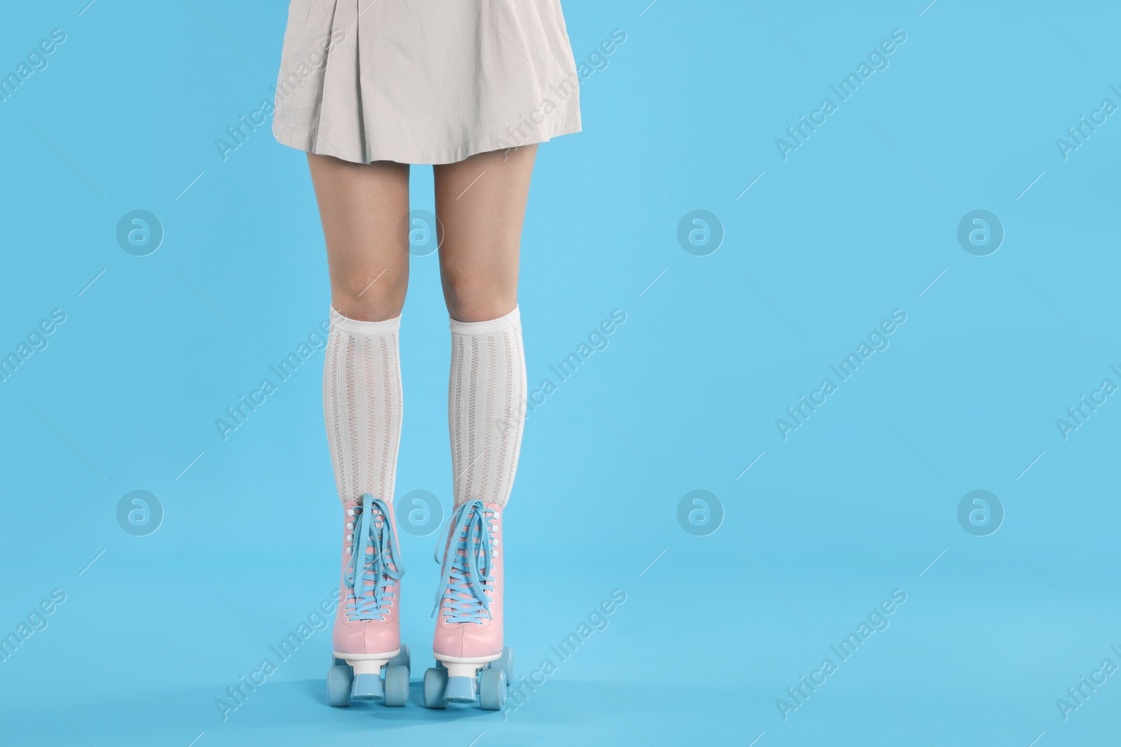 Woman in roller skates on light blue background, closeup. Space for text Photo of Woman in roller skates on light blue background, closeup. Space for text