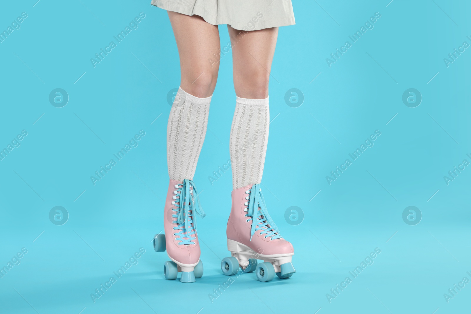 Woman in roller skates on light blue background, closeup Photo of Woman in roller skates on light blue background, closeup